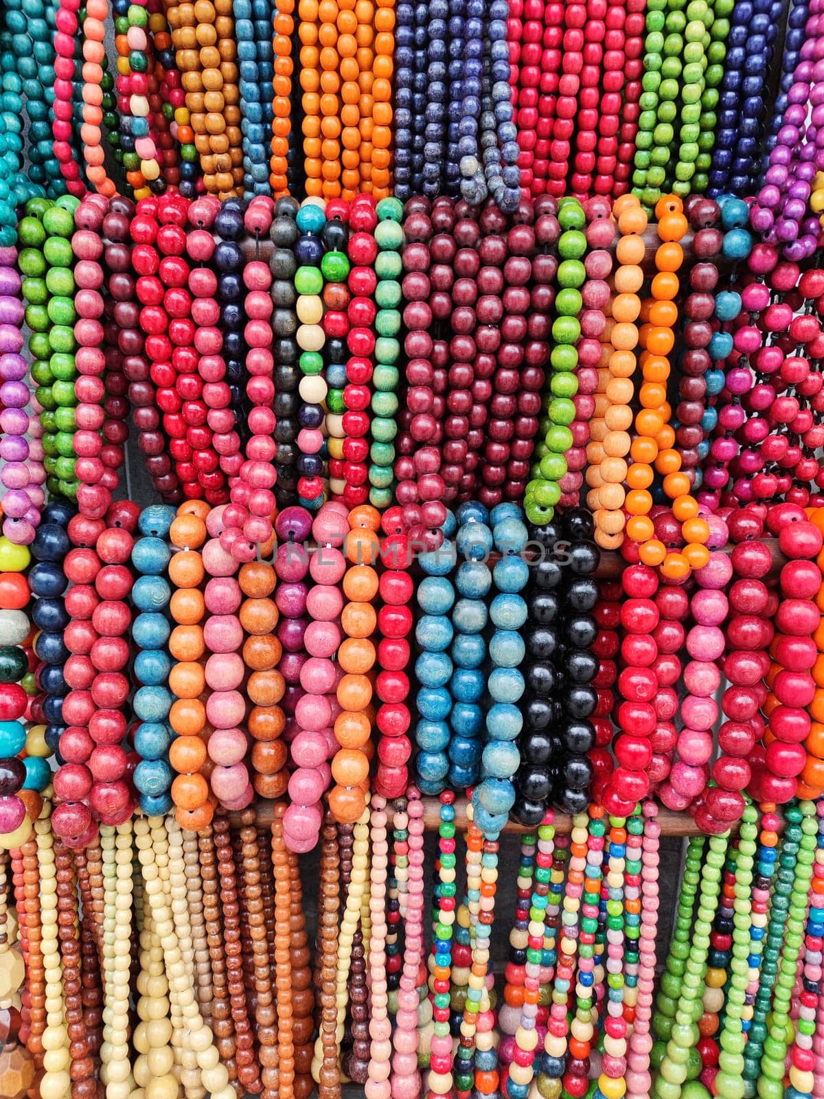 multi-colored beads hang in a street shop for a multi-colored background.