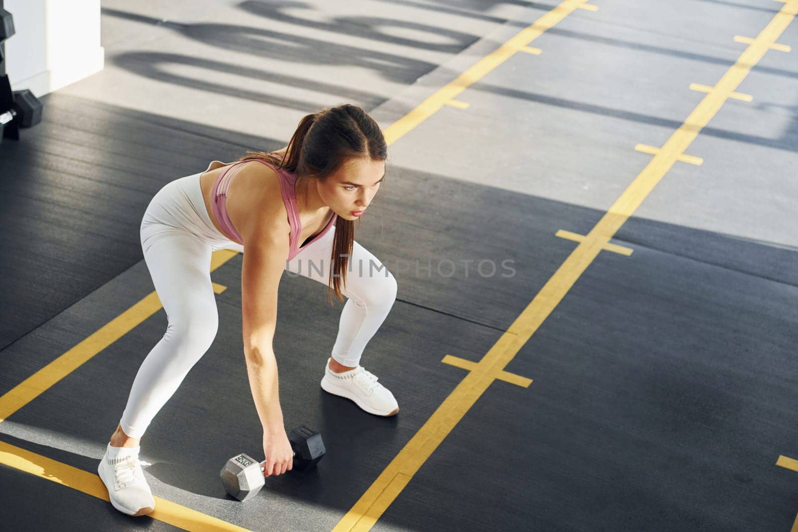 Young woman with slim body type is in the gym.