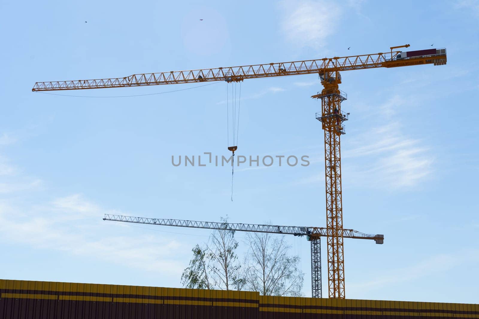 Construction cranes against the blue sky. Bottom view. Building concept.