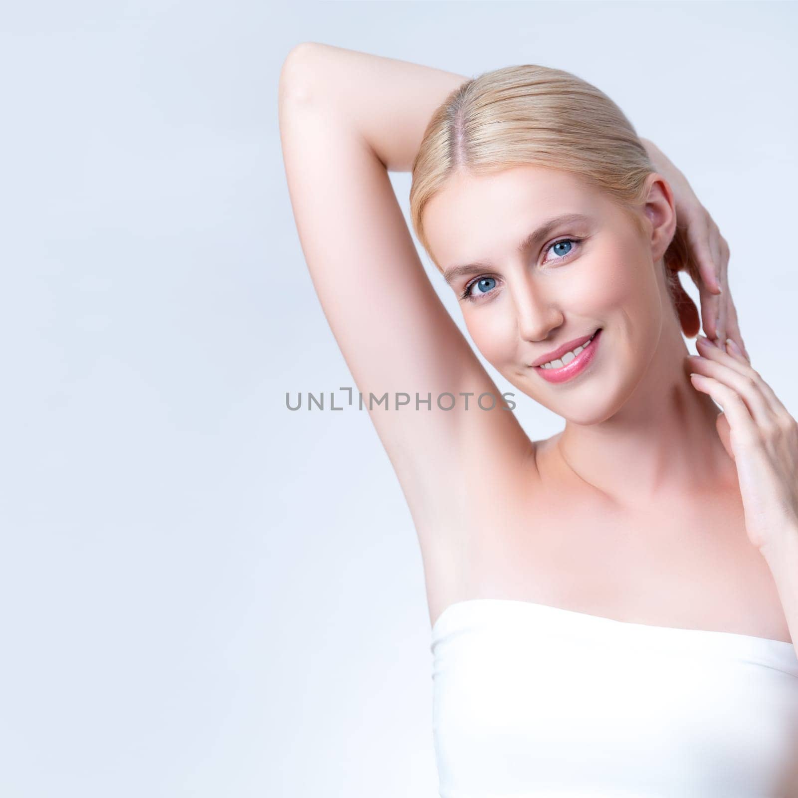 Personable woman showing her clean and smooth skin armpit in isolated background by biancoblue