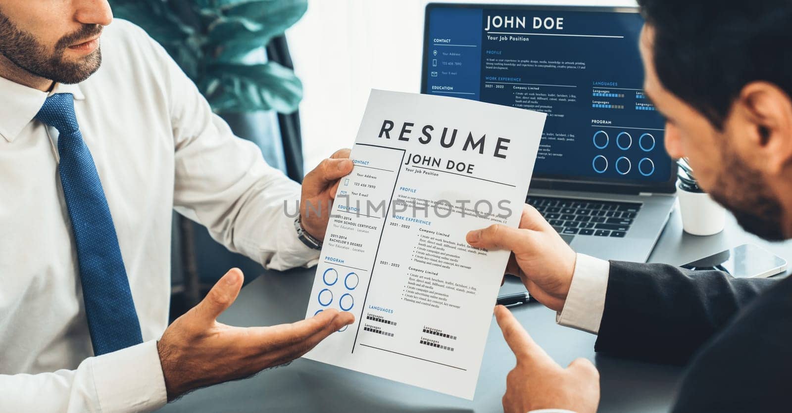 Interviewing job applicant in office with resume paper. Candidate wear suit for formal conversation with interviewer. Recruitment process with question about career and work experience. Fervent