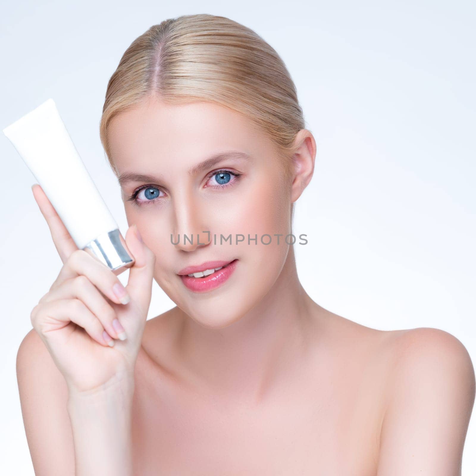 Closeup personable beautiful perfect natural skin woman hold mockup tube moisturizer cream for skincare treatment product advertising expressive facial and gesture expression in isolated background.