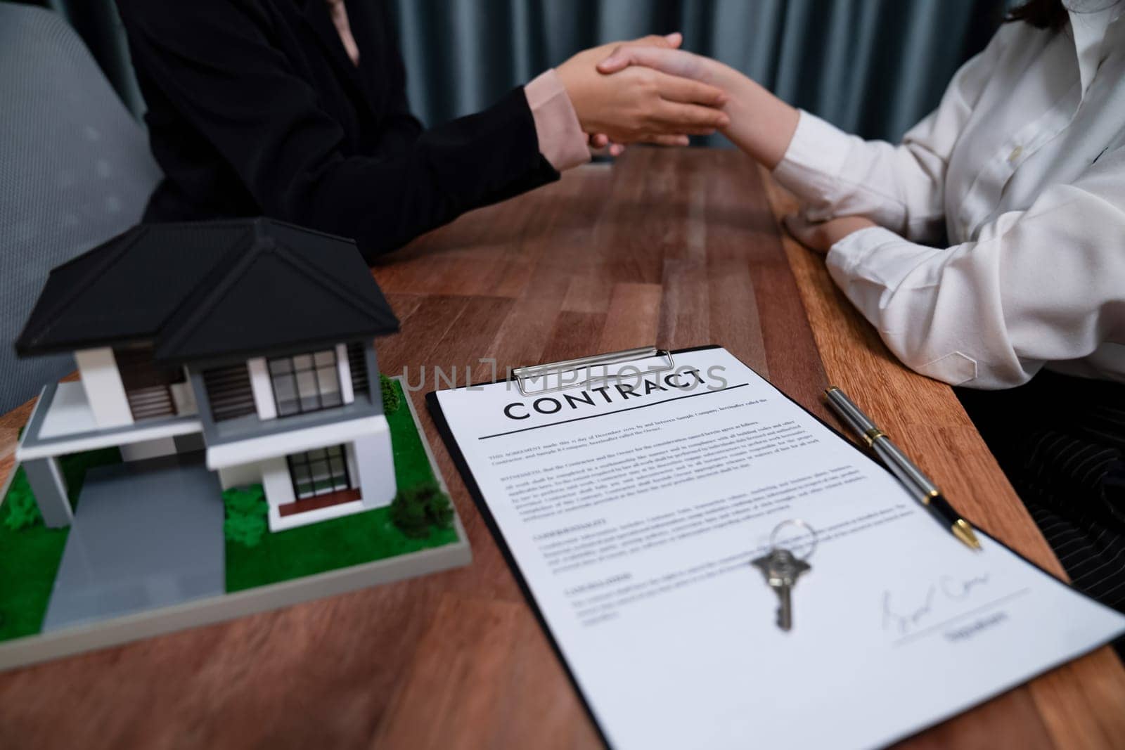 Successful house loan agreement sealed with a handshake. Buyers and agents celebrate the home ownership of property with a sense of accomplishment and satisfaction. Enthusiastic