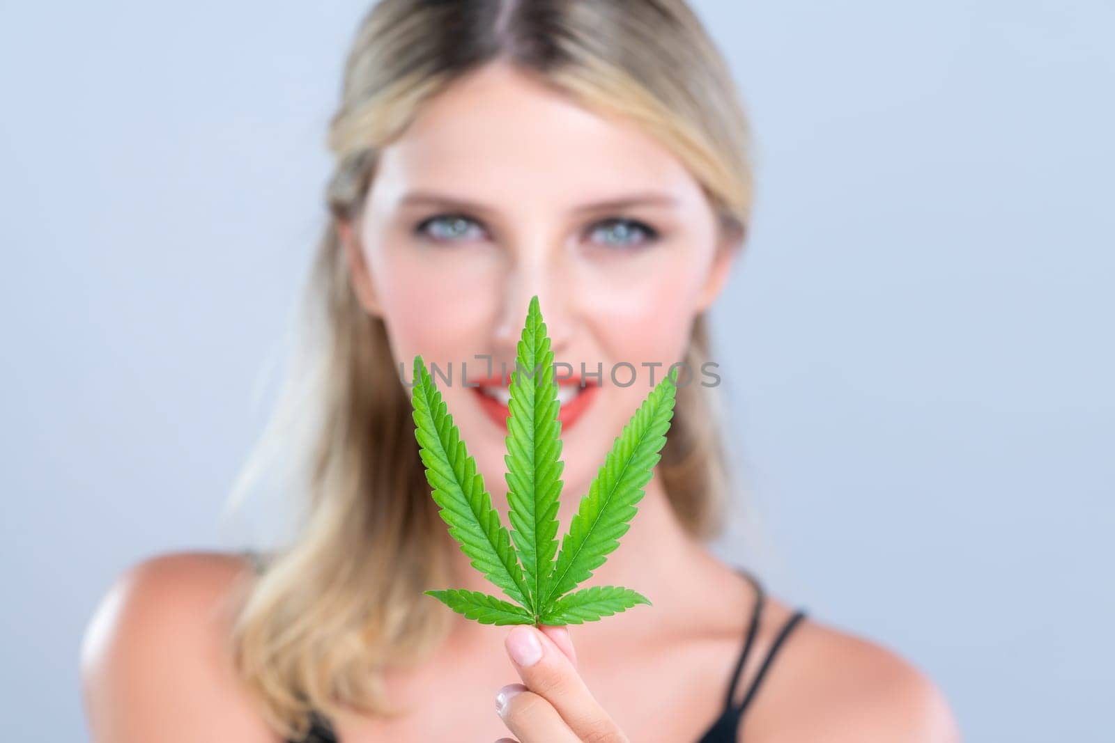 Closeup alluring woman portrait hold green leaf as cannabis beauty concept. by biancoblue