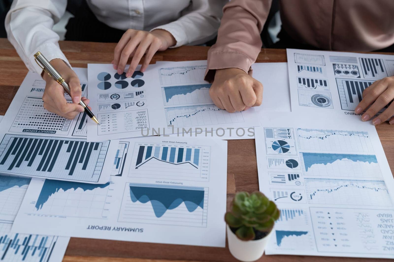 Closeup analyst team colleagues discuss financial data on digital dashboard, analyzing charts and graph with supportive teamwork. Professional office use BI to plan marketing business. Enthusiastic