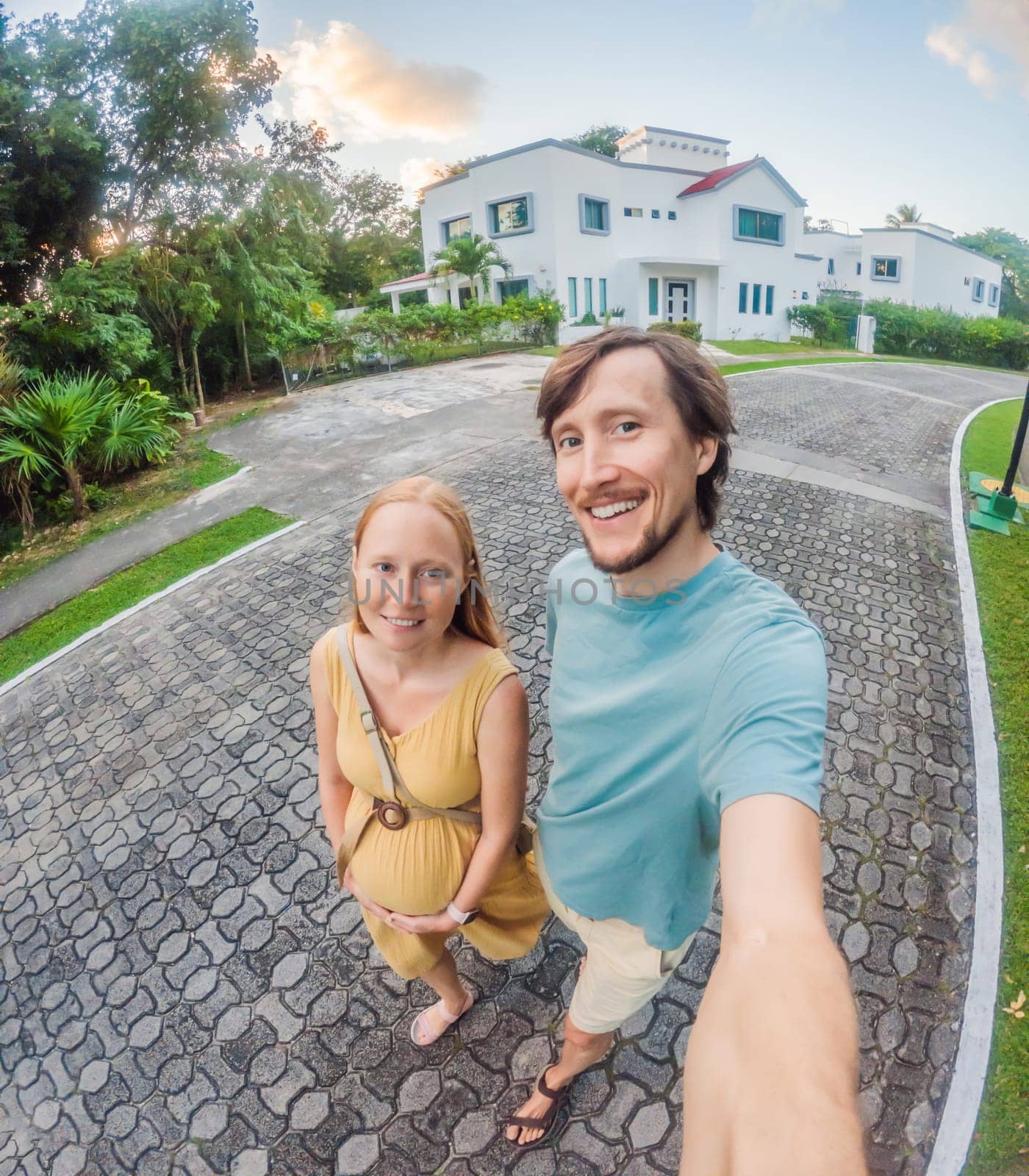 Husband with his pregnant wife walking in a residential area by galitskaya