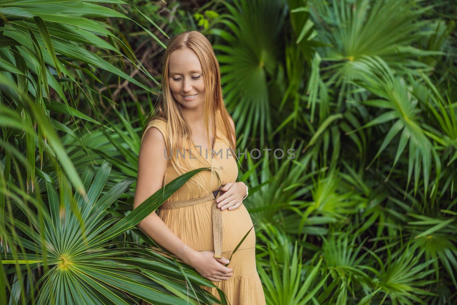 Pregnant woman walks in park at evening. Family enjoying pregnancy. The concept of Mother's Day and Women's Day.