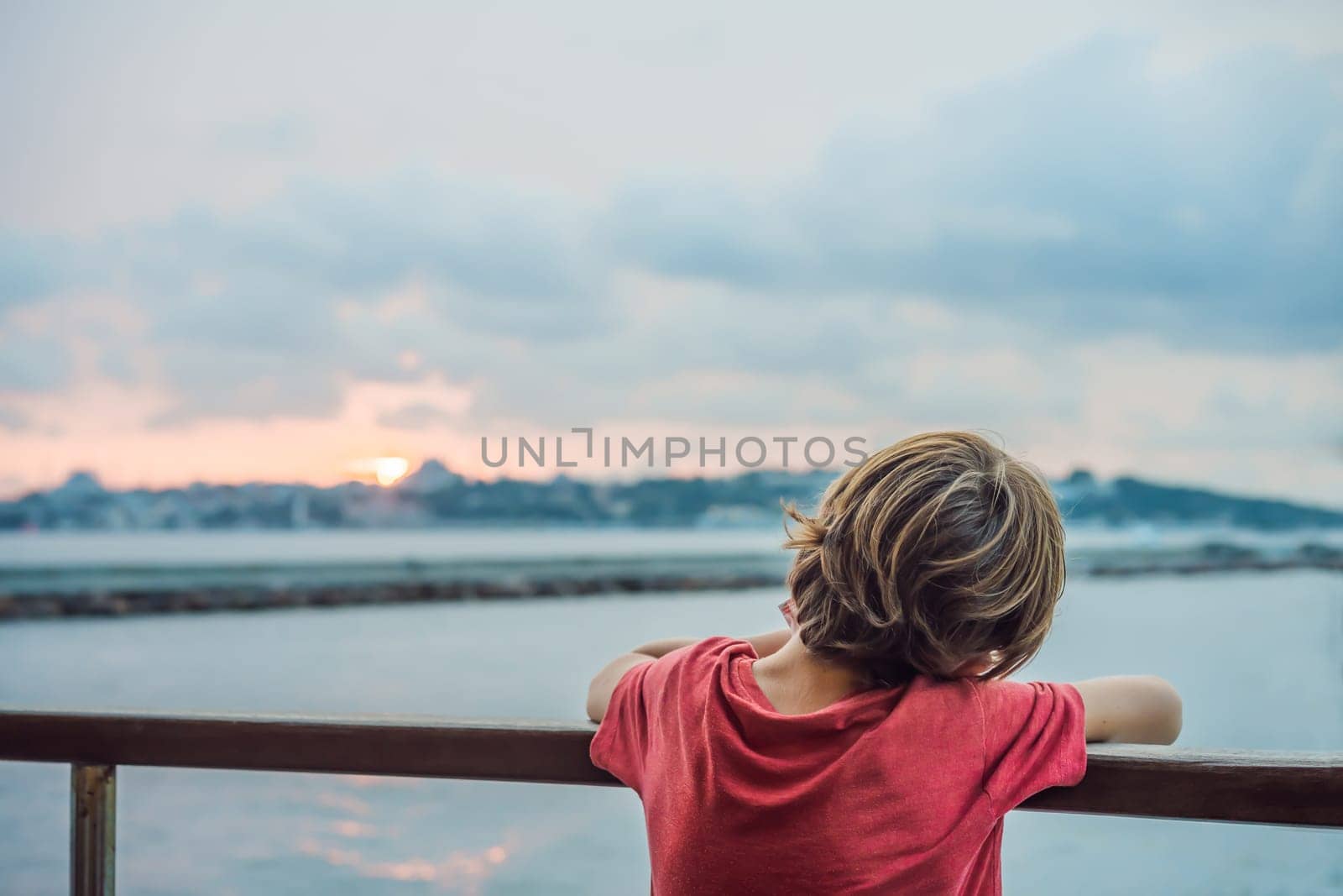 Happy boy enjoying the sea from ferry boat crossing Bosphorus in Istanbul. Summer trip to Istanbul. Traveling with kids concept.