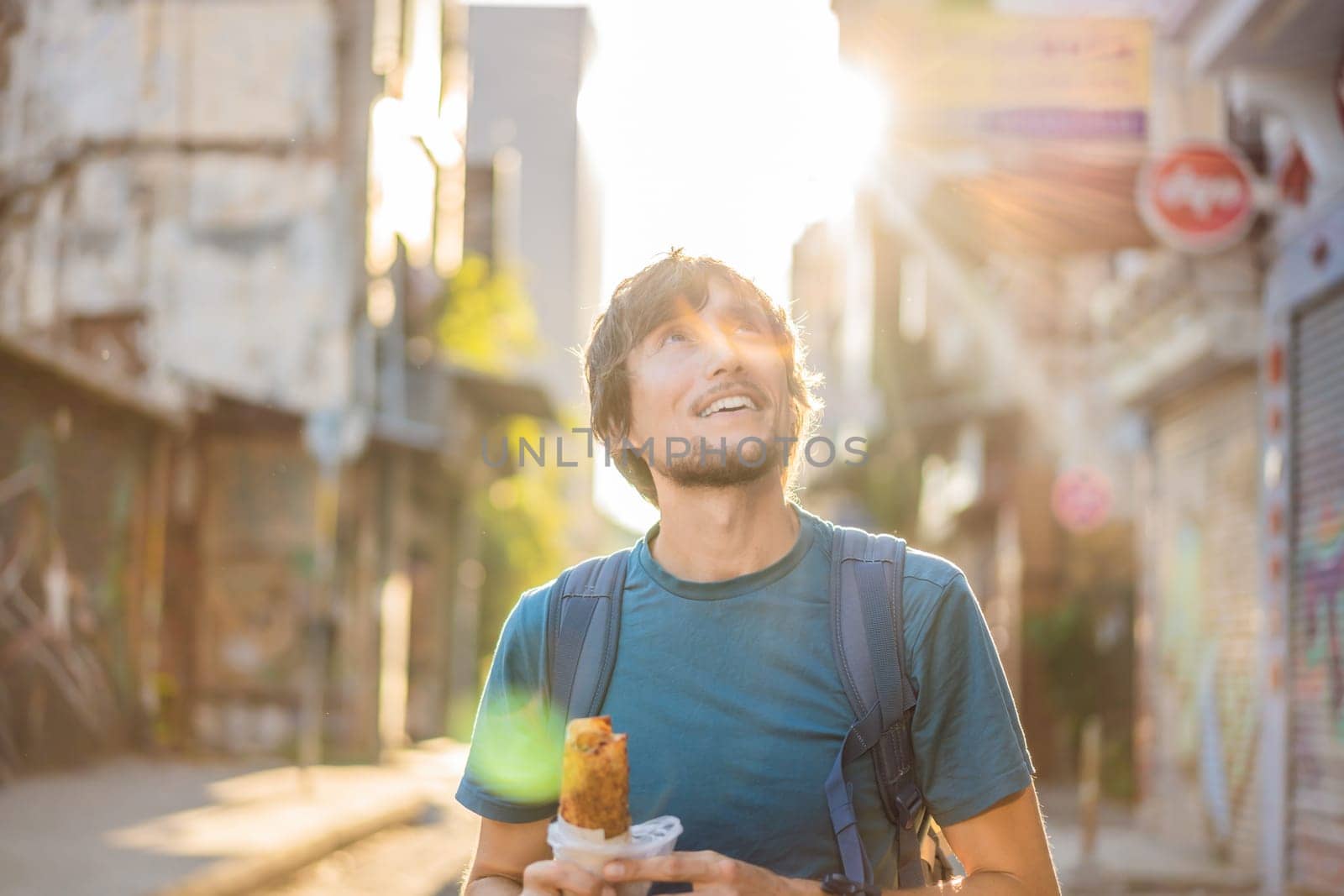 Man eating street food in Istanbul. Balik ekmek - fish in a bread, traditional Turkish fast food. Istanbul, Turkey.