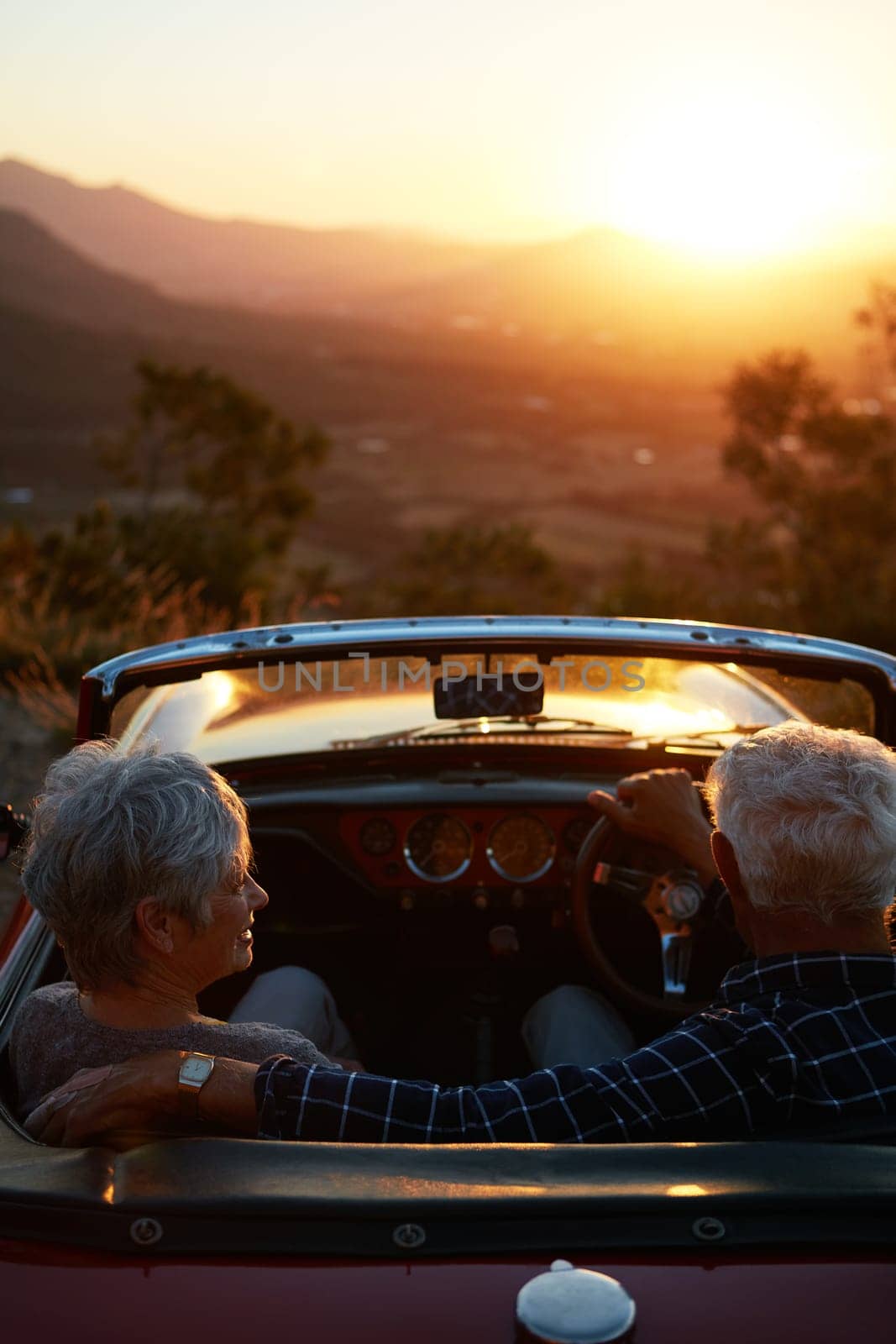 To travel is to truly live. an affectionate senior couple enjoying the sunset during a roadtrip. by YuriArcurs