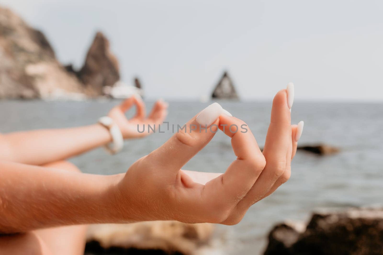 Woman sea yoga. Happy woman meditating in yoga pose on the beach, ocean and rock mountains. Motivation and inspirational fit and exercising. Healthy lifestyle outdoors in nature, fitness concept. by panophotograph