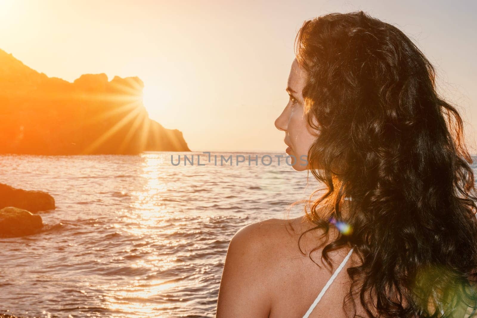 Woman sea yoga. Happy woman in white swimsuit and boho style braclets practicing outdoors on yoga mat by sea on sunset. Women yoga fitness routine. Healthy lifestyle, harmony and meditation by panophotograph