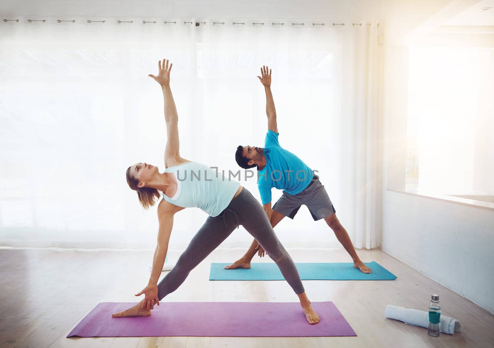 Yoga draws us closer together. a couple practising yoga at home