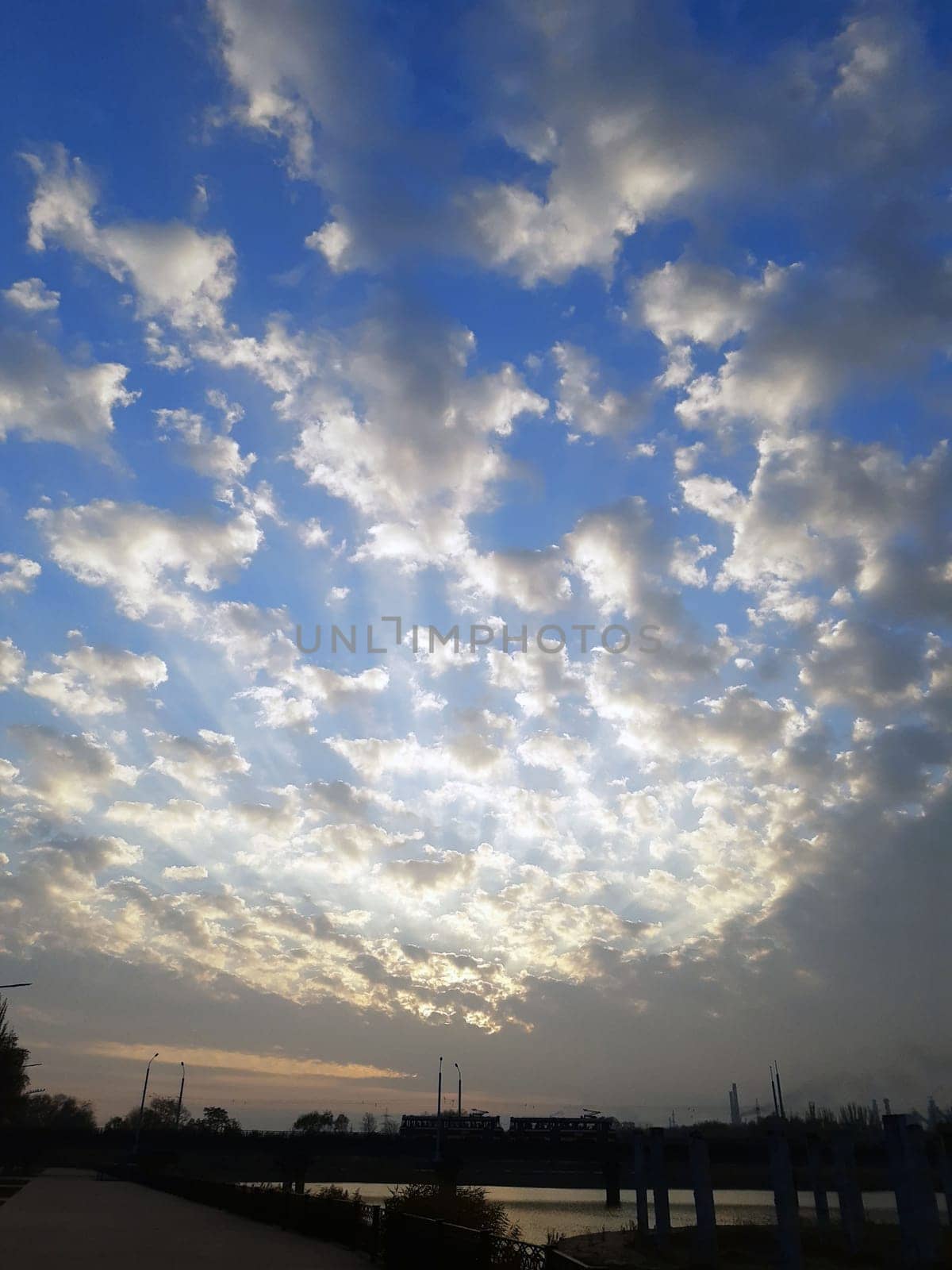 High-speed tram against the background of the morning rising sun and clouds by Endusik