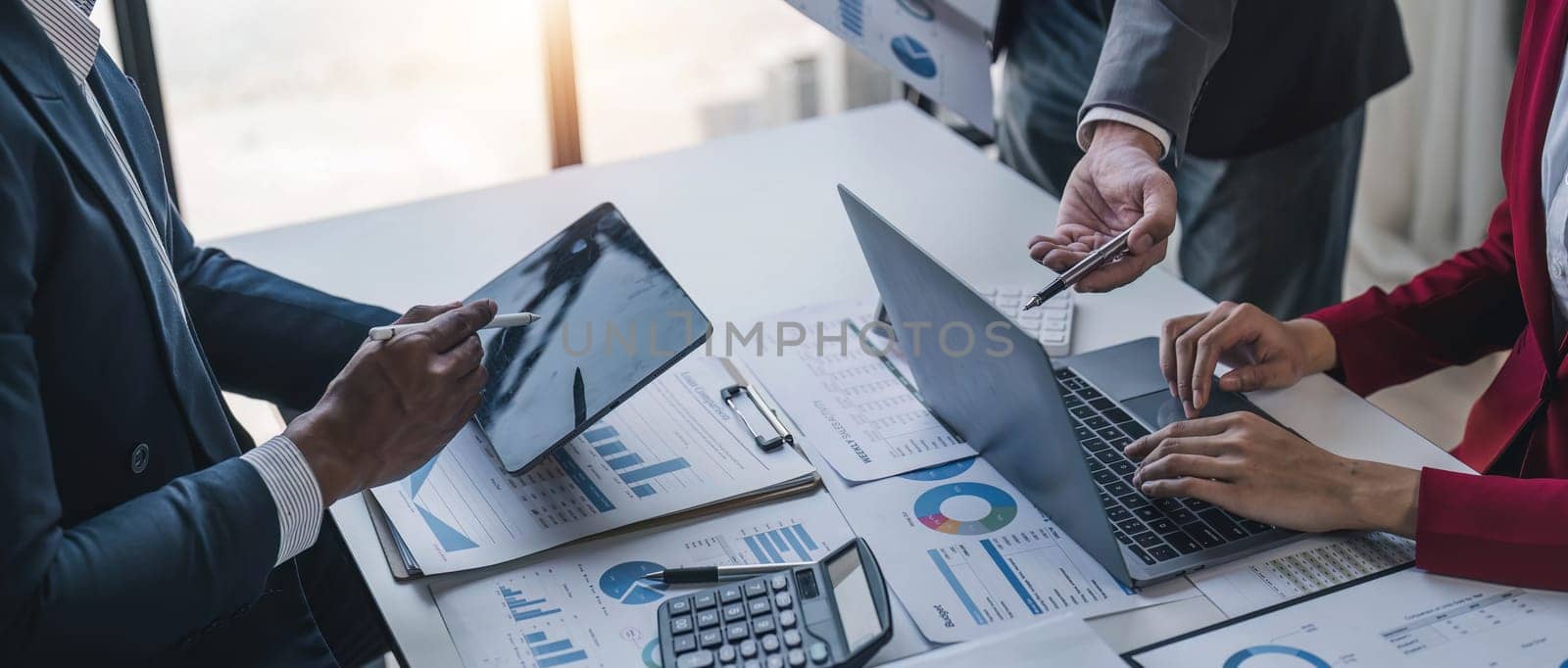 Business People Meeting using laptop computer,calculator,notebook,stock market chart paper for analysis Plans to improve quality next month. Conference Discussion Corporate Concept.