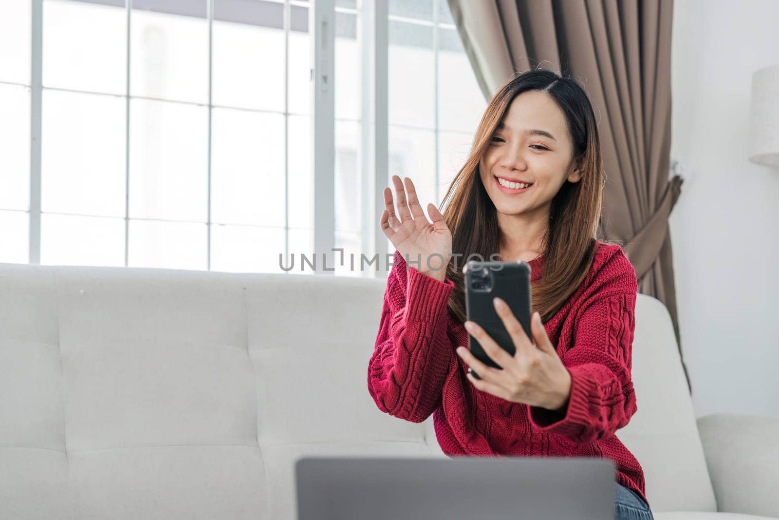 Satisfied asian woman relaxing on comfortable couch, using laptop at home, happy girl chatting with friends in social network, spending lazy weekend, watching movie, shopping online, writing email by wichayada