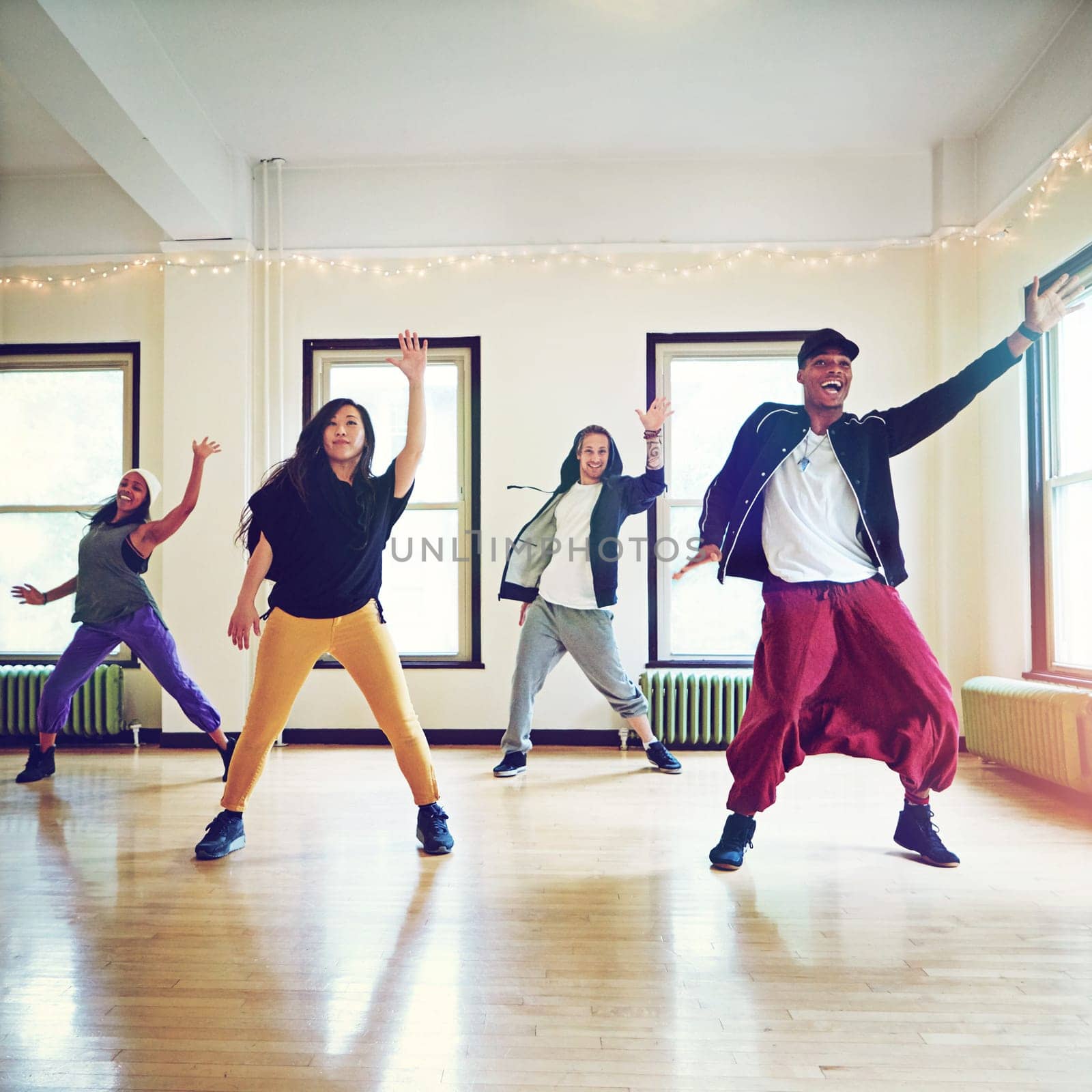 Talent that will take them to the top. a group of young people dancing together in a studio. by YuriArcurs