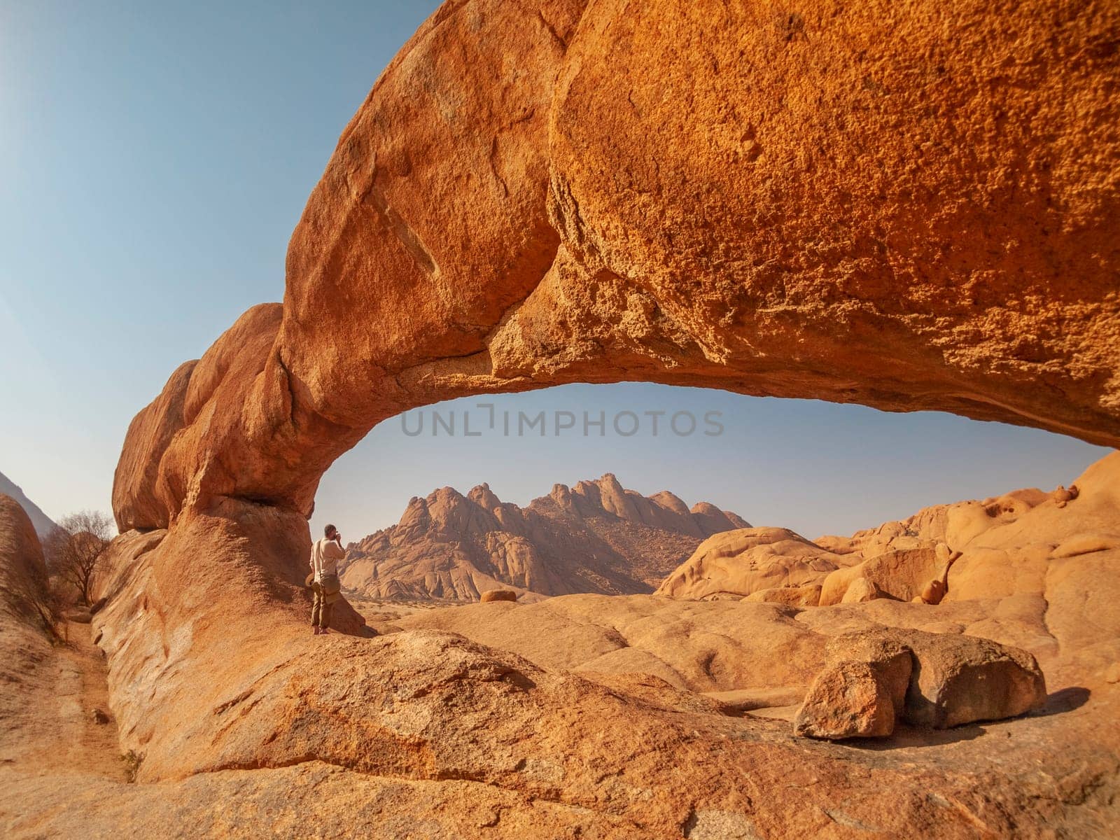 Taking pictures under the rock arch in the Spitzkoppe National Park in Namibia, Africa.