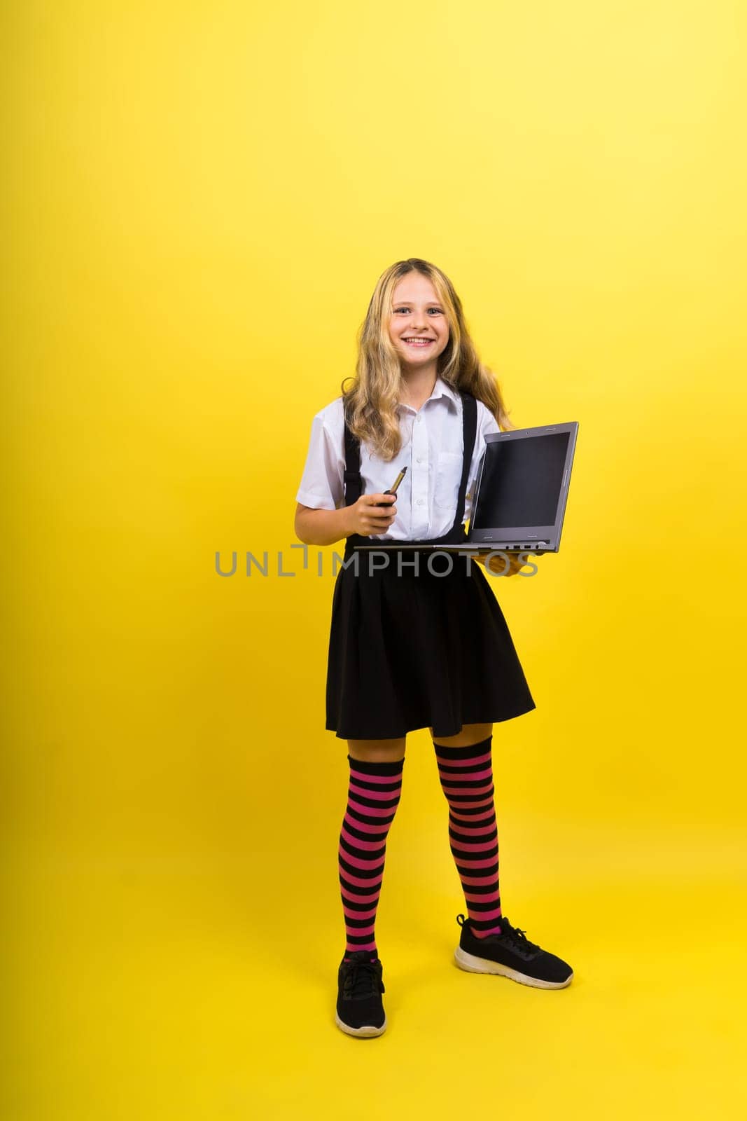 Little happy blonde kid girl 12-13 years laptop computer. Children lifestyle childhood concept.