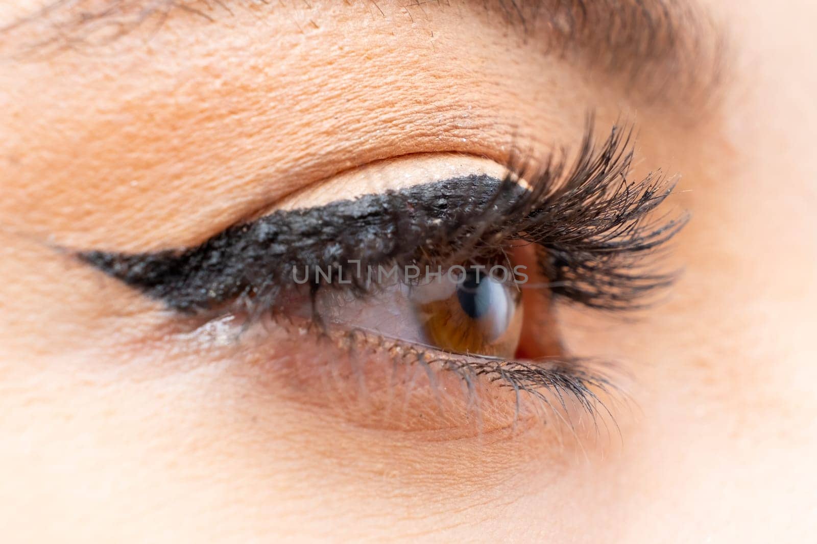 Close up woman eye with perfect black eyeliner and long eyelashes.