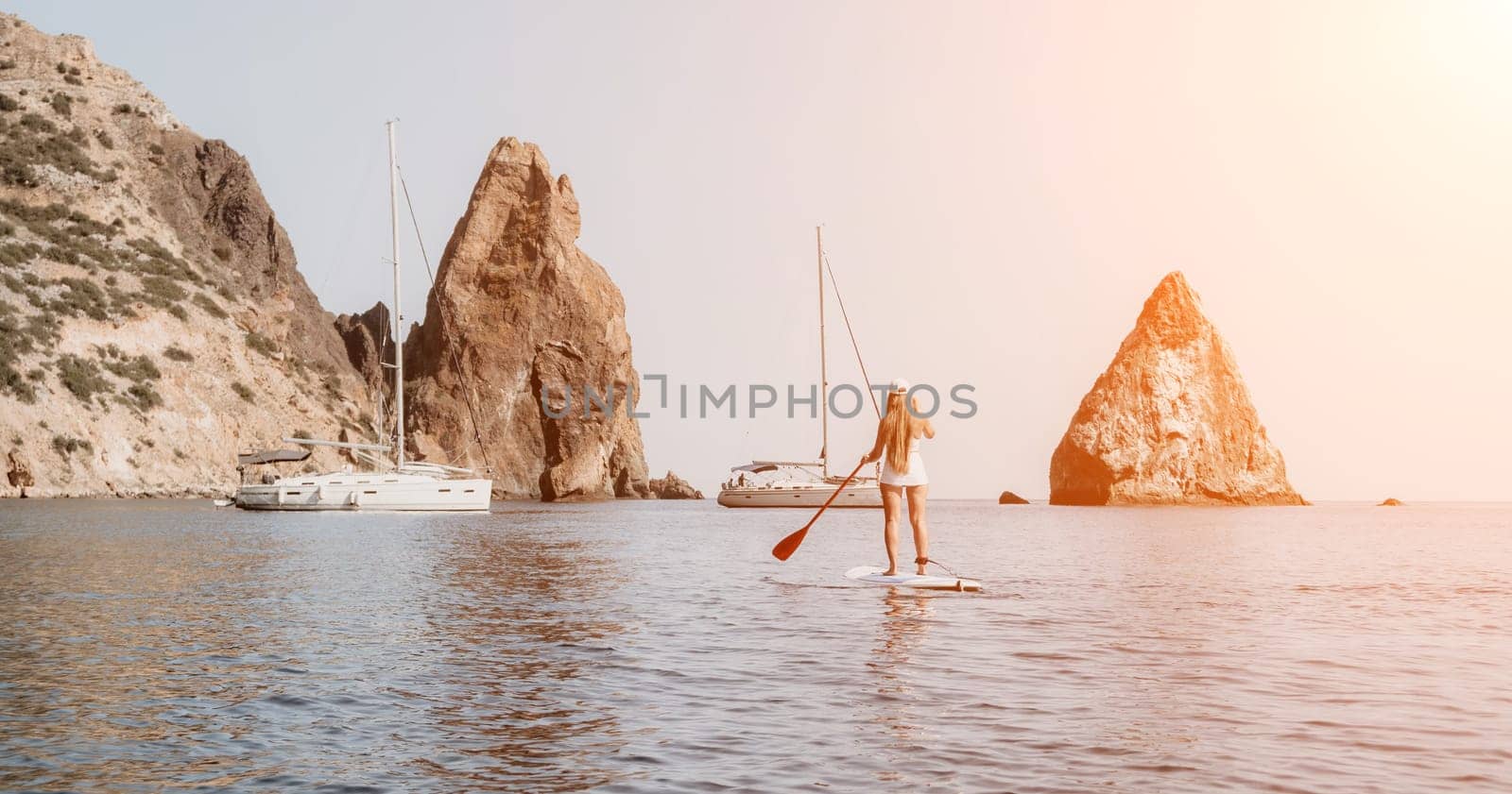 Woman sea sup. Close up portrait of happy young caucasian woman with long hair looking at camera and smiling. Cute woman portrait in bikini posing on sup board in the sea by panophotograph