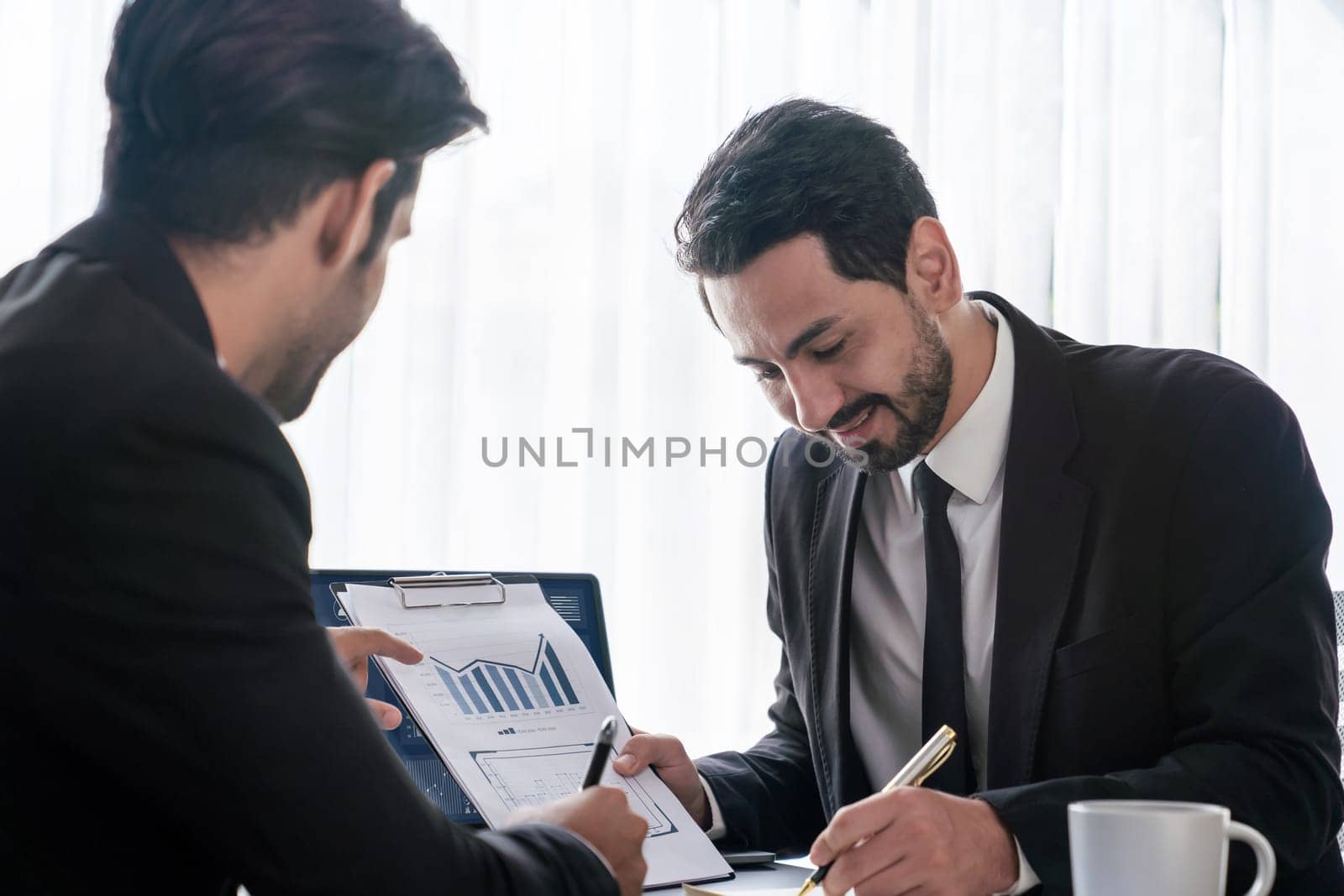 Busy analyst team discussing financial data on digital dashboard, analyzing chart and graph using data science software display on a laptop screen. Business intelligence and Fintech. Fervent