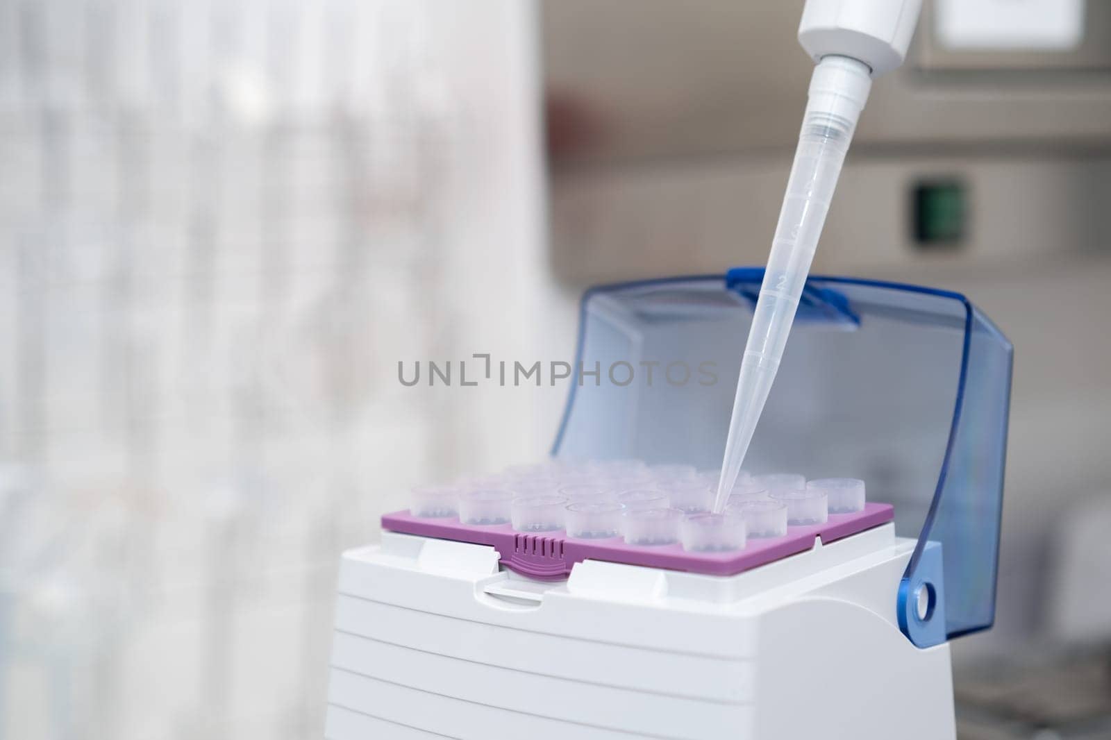 Close up scientist hand takes plastic tip for automatic pipette from the box for sample collection. Medical research laboratory.