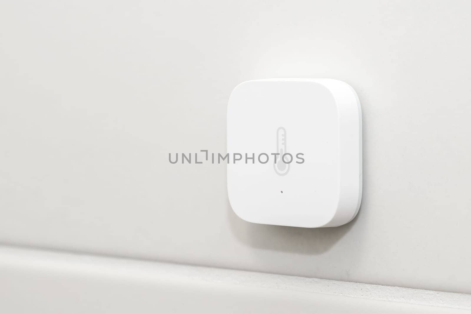 Smart heat sensor on the white wall.