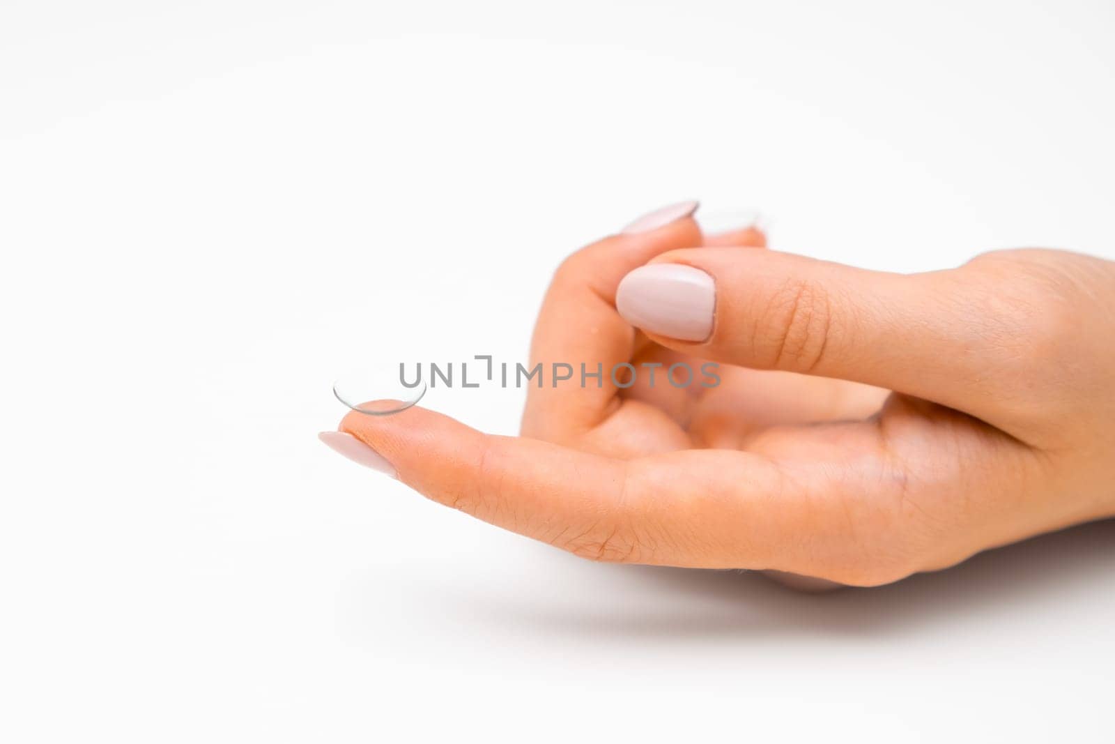 Disposable contact lenses on the tip of the finger on the white background with copy space.