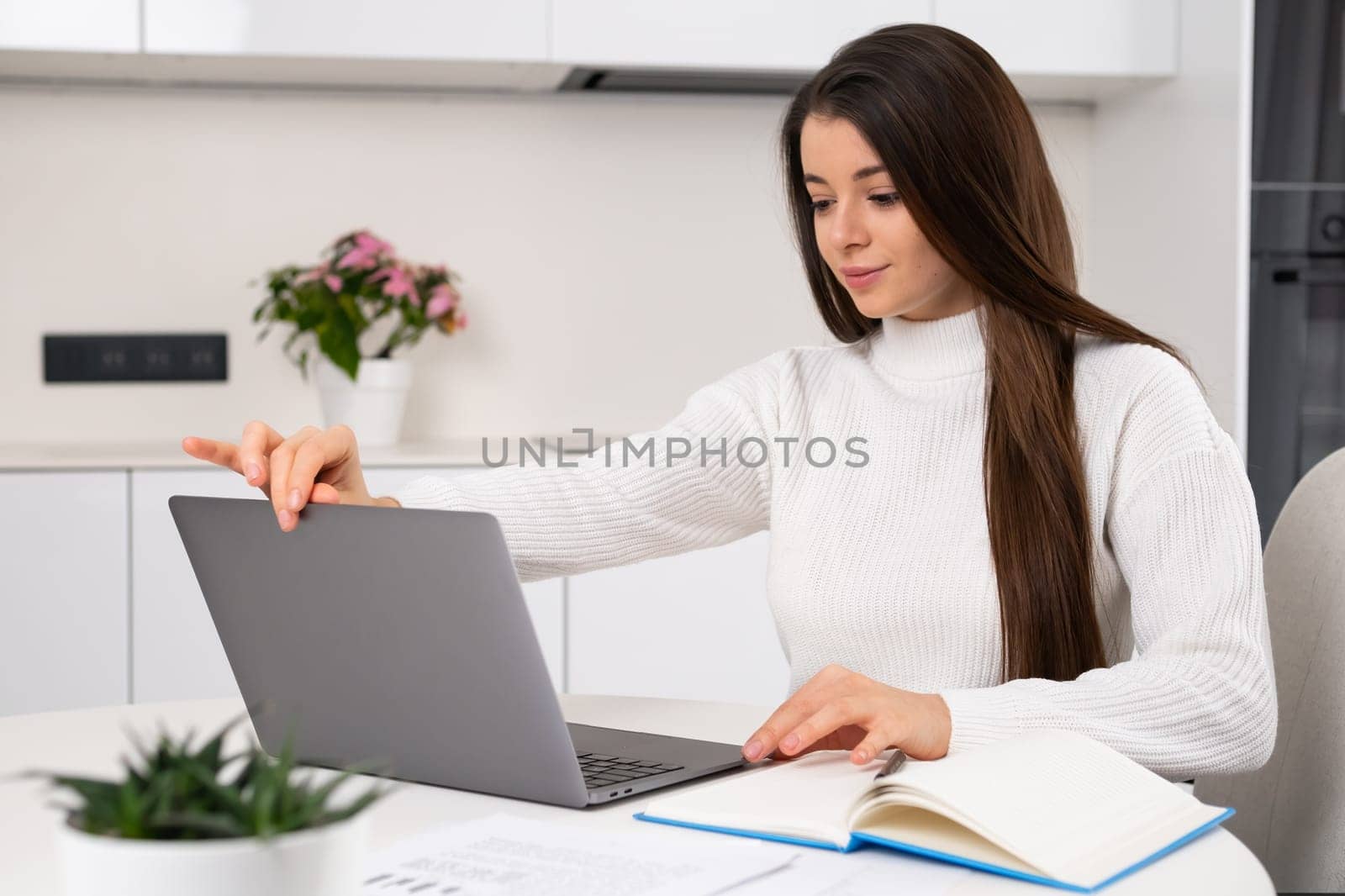 Smart pretty young woman opens laptop for study online at home