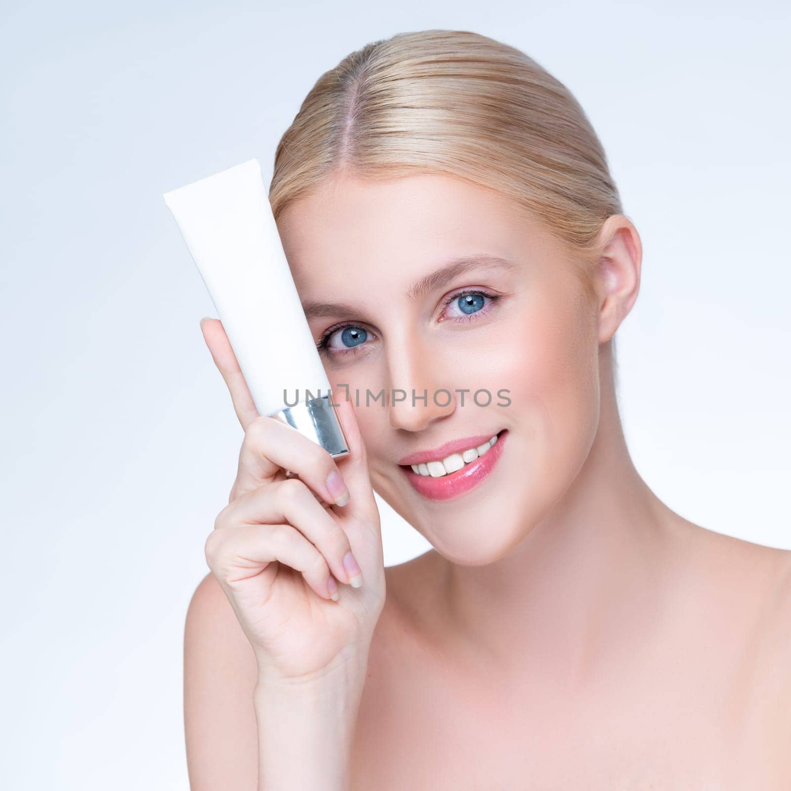 Closeup personable beautiful perfect natural skin woman hold mockup tube moisturizer cream for skincare treatment product advertising expressive facial and gesture expression in isolated background.