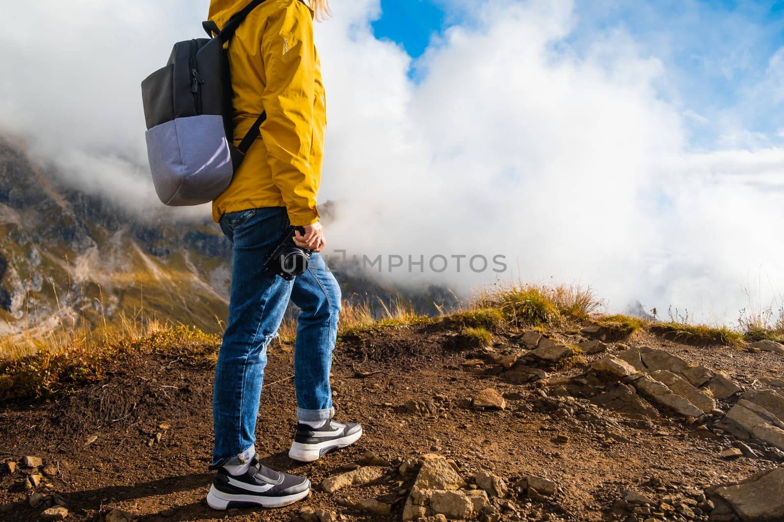 Tourist stands on the top of mountains and enjoys the view of the Giau Pass in Italy.