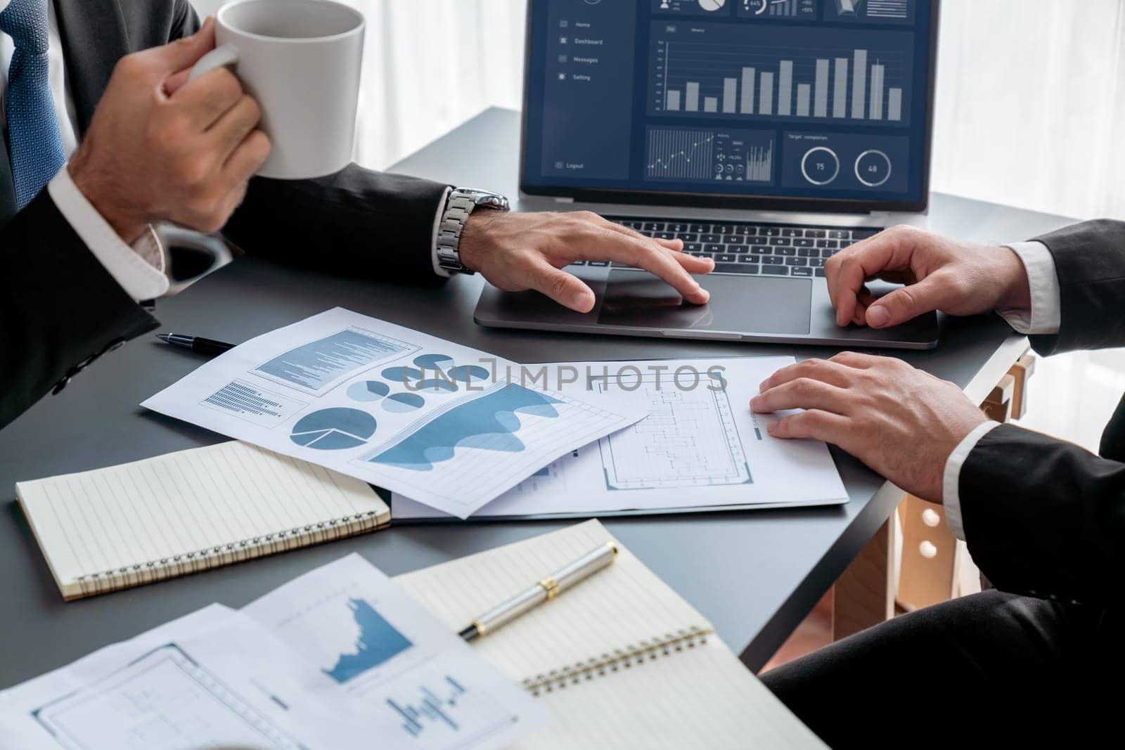 Closeup busy analyst team with coffee discuss financial data on digital dashboard, analyzing chart and graph using business technology display on laptop screen. Fintech business intelligence. Fervent