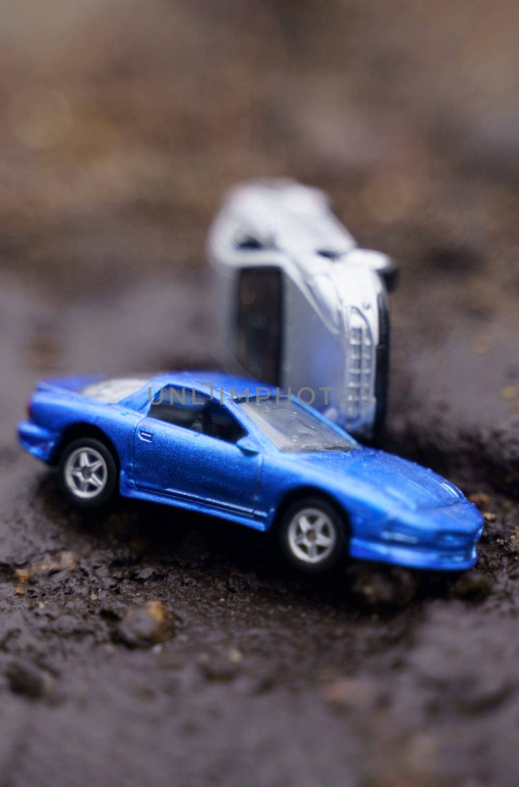Natural disasters. One car overturned on another as a result of a landslide. One of them is out of focus.