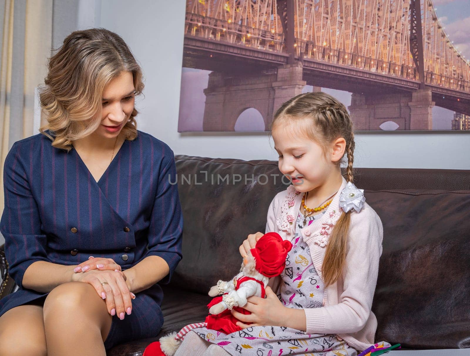 The girl psychologist plays a puppet character game with the child