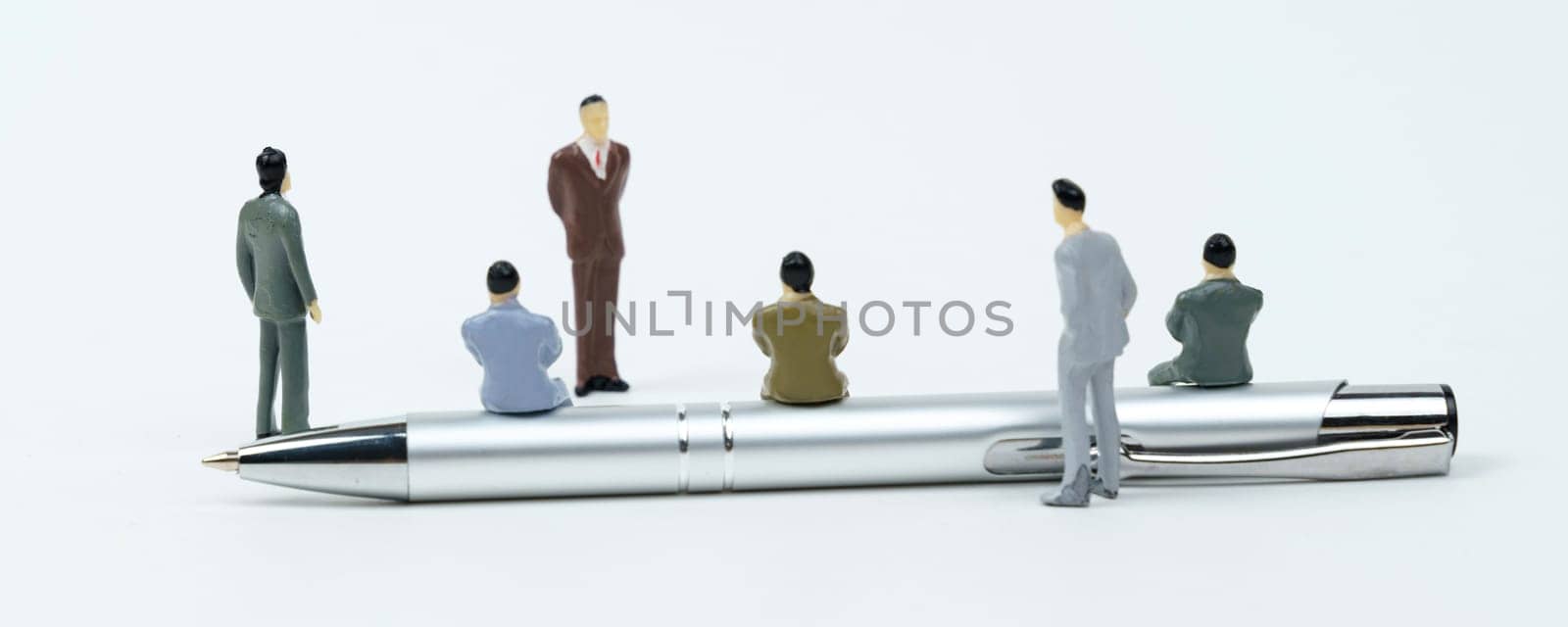 On a white surface are miniature figures of businessmen - holding a meeting, a seminar. by Sd28DimoN_1976