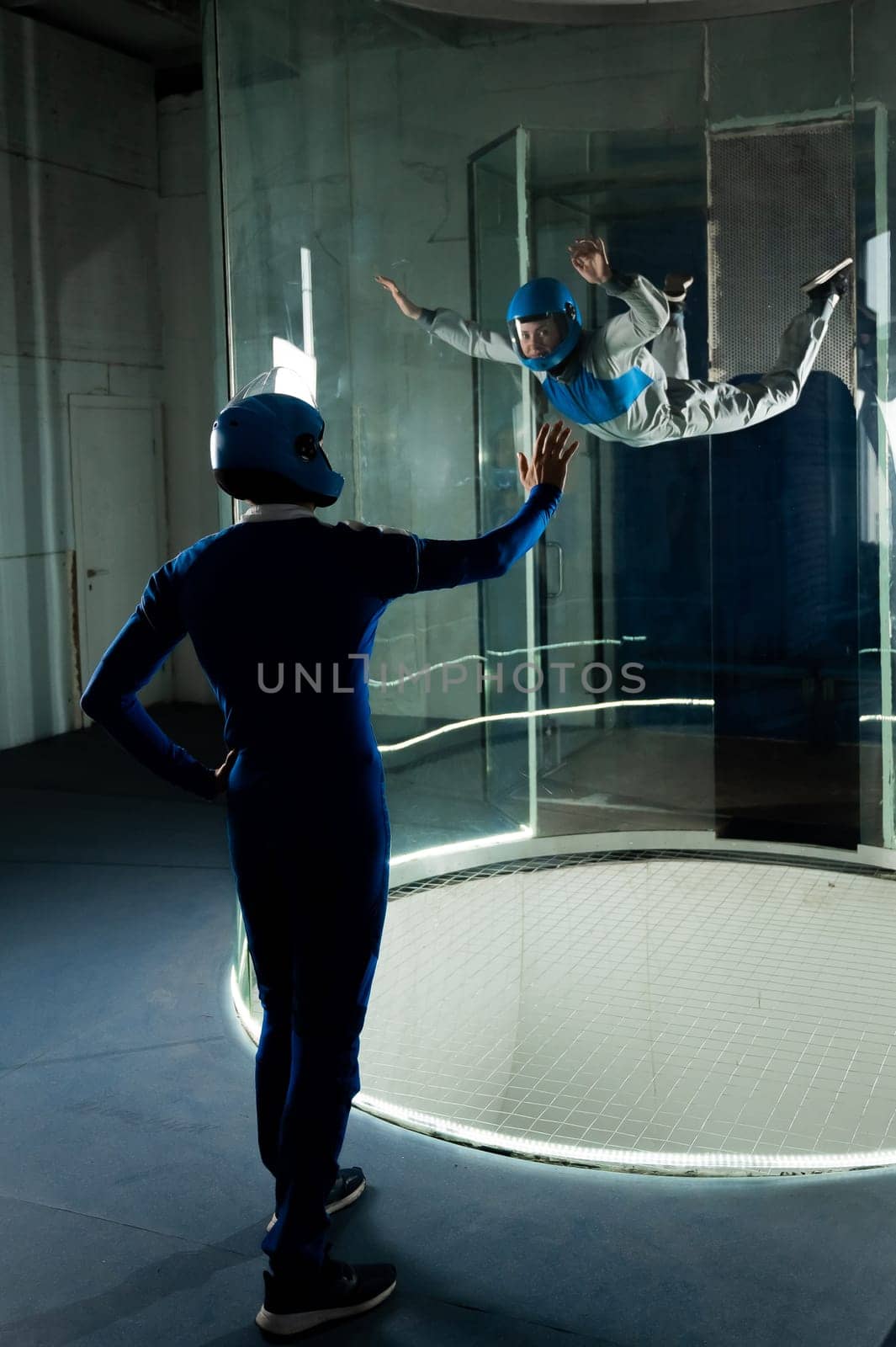 A male instructor teaches a woman how to fly in a wind tunnel. Free fall simulator. by mrwed54