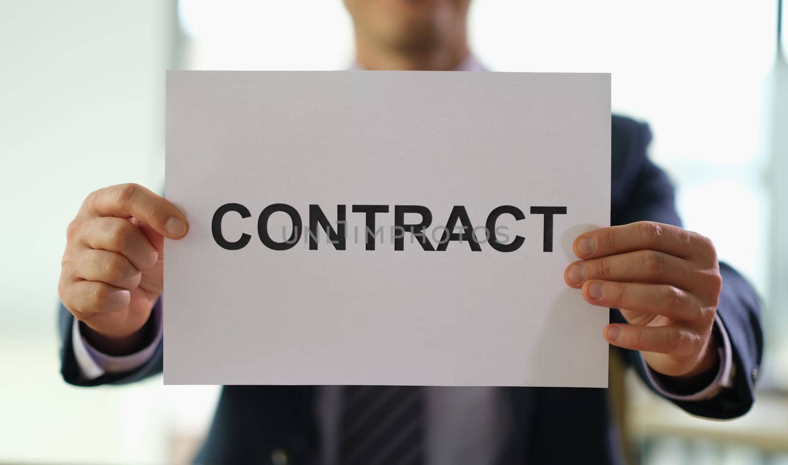 Businessman holding paper document contract in hands in office closeup. Employment and profitable deals concept