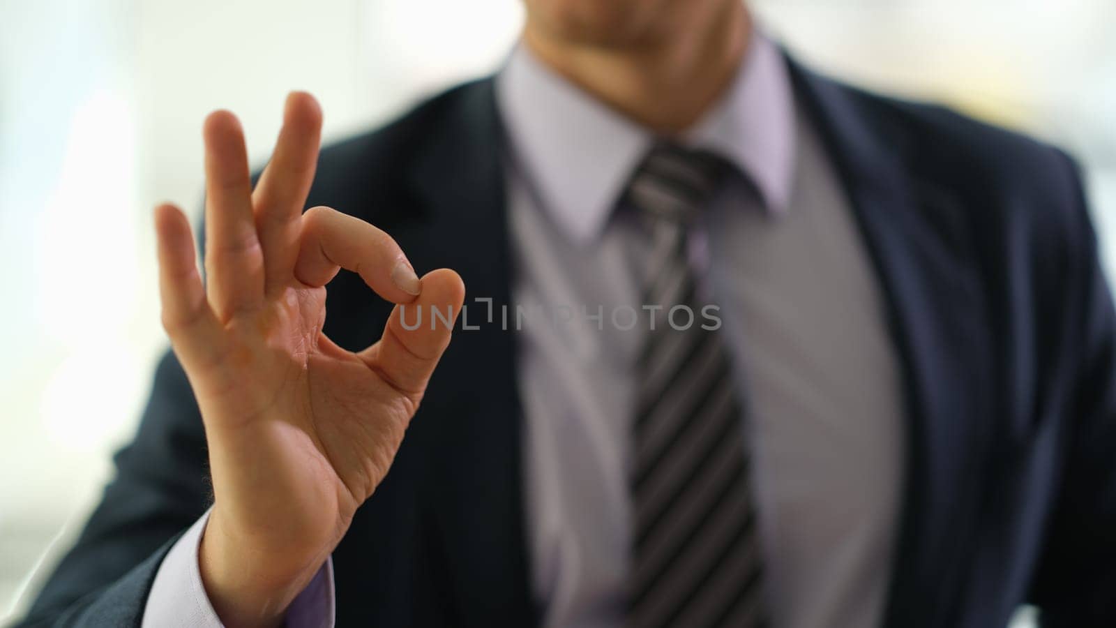 Businessman manager showing ok gesture in office closeup. Successful professional career in business concept