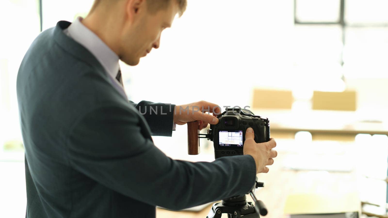 Business coach in suit adjusting camera to audience closeup. Business blogging concept