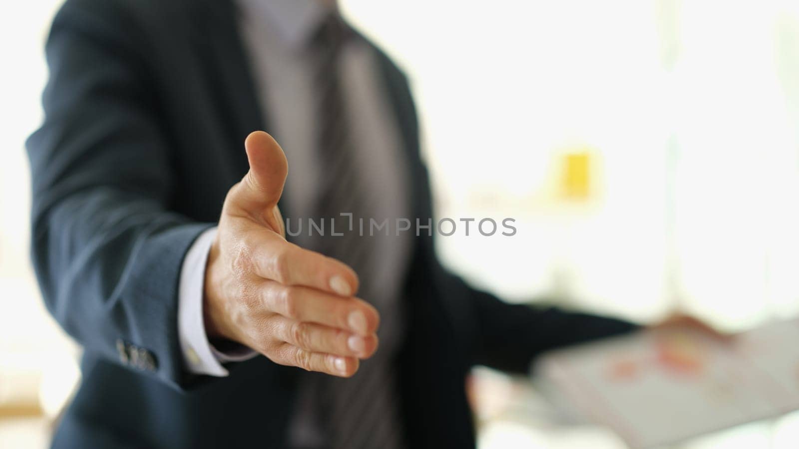 Businessman manager stretching out hand for handshake to partner in office closeup. Team work concept
