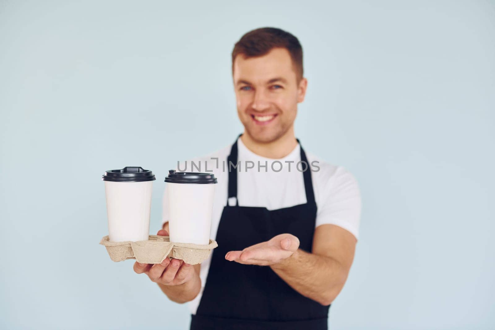 Man in uniform standing in the studio with drinks in hands.