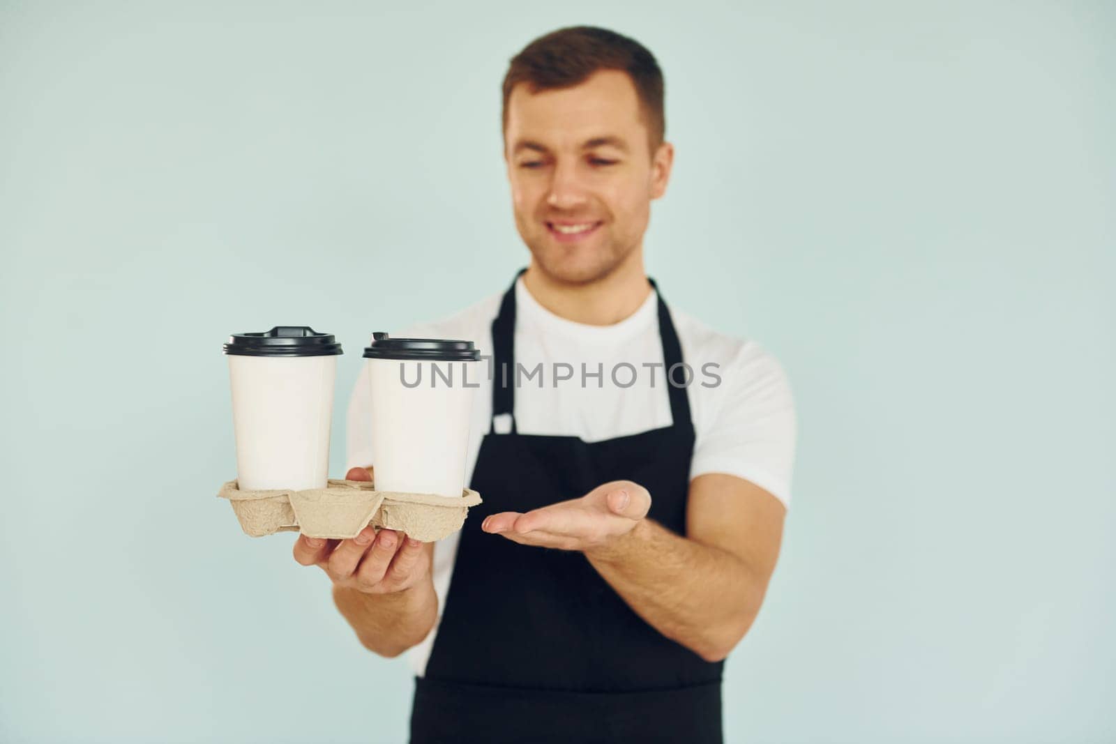 Man in uniform standing in the studio with drinks in hands.