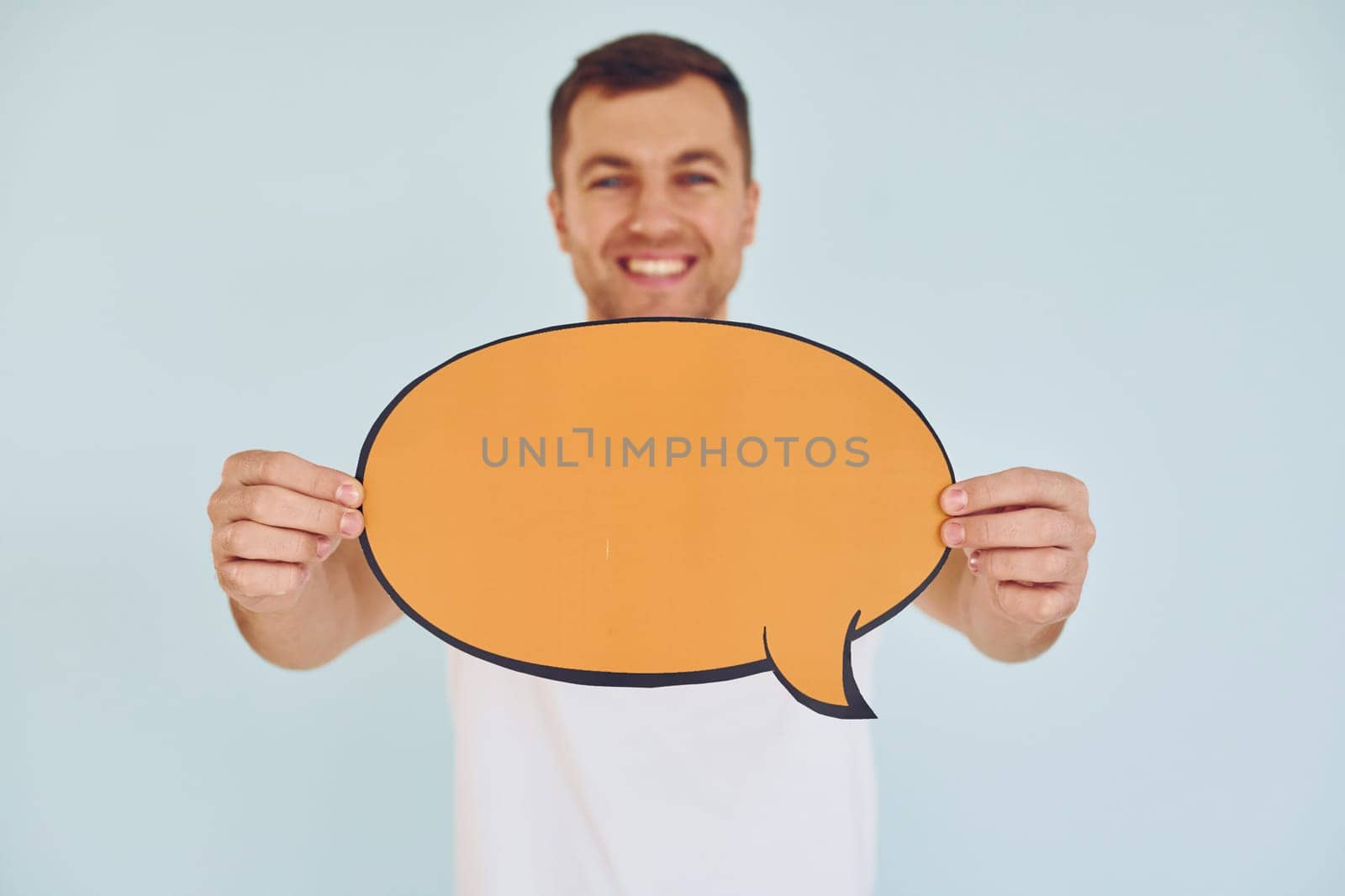 In white shirt. Man standing in the studio with empty signs for the text.