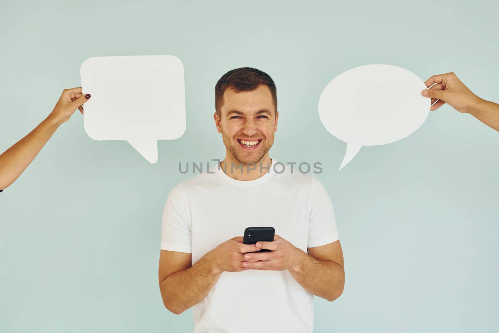 Conversation text. Man standing in the studio with empty signs.