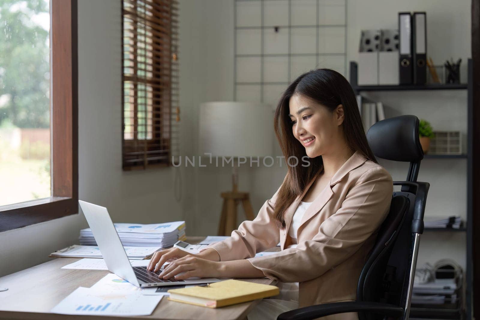 Young Happy Businesswoman Using Computer in Modern Office with Colleagues by nateemee