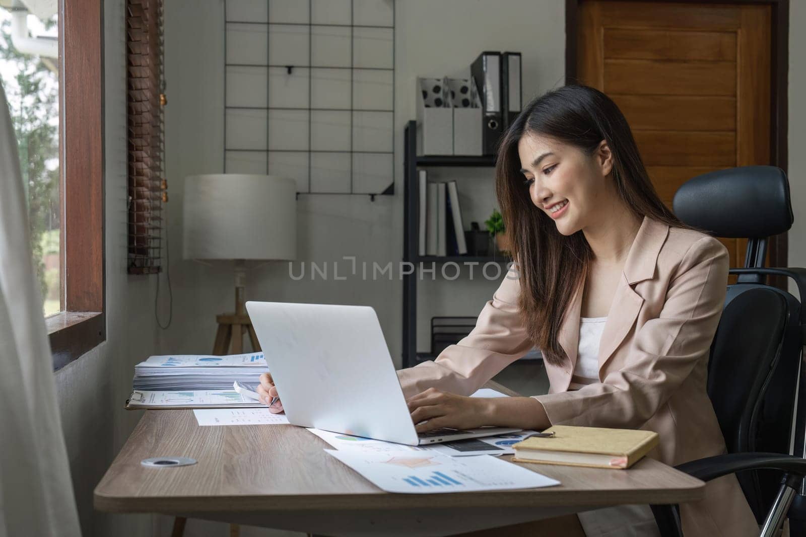 Young Happy Businesswoman Using Computer in Modern Office with Colleagues.