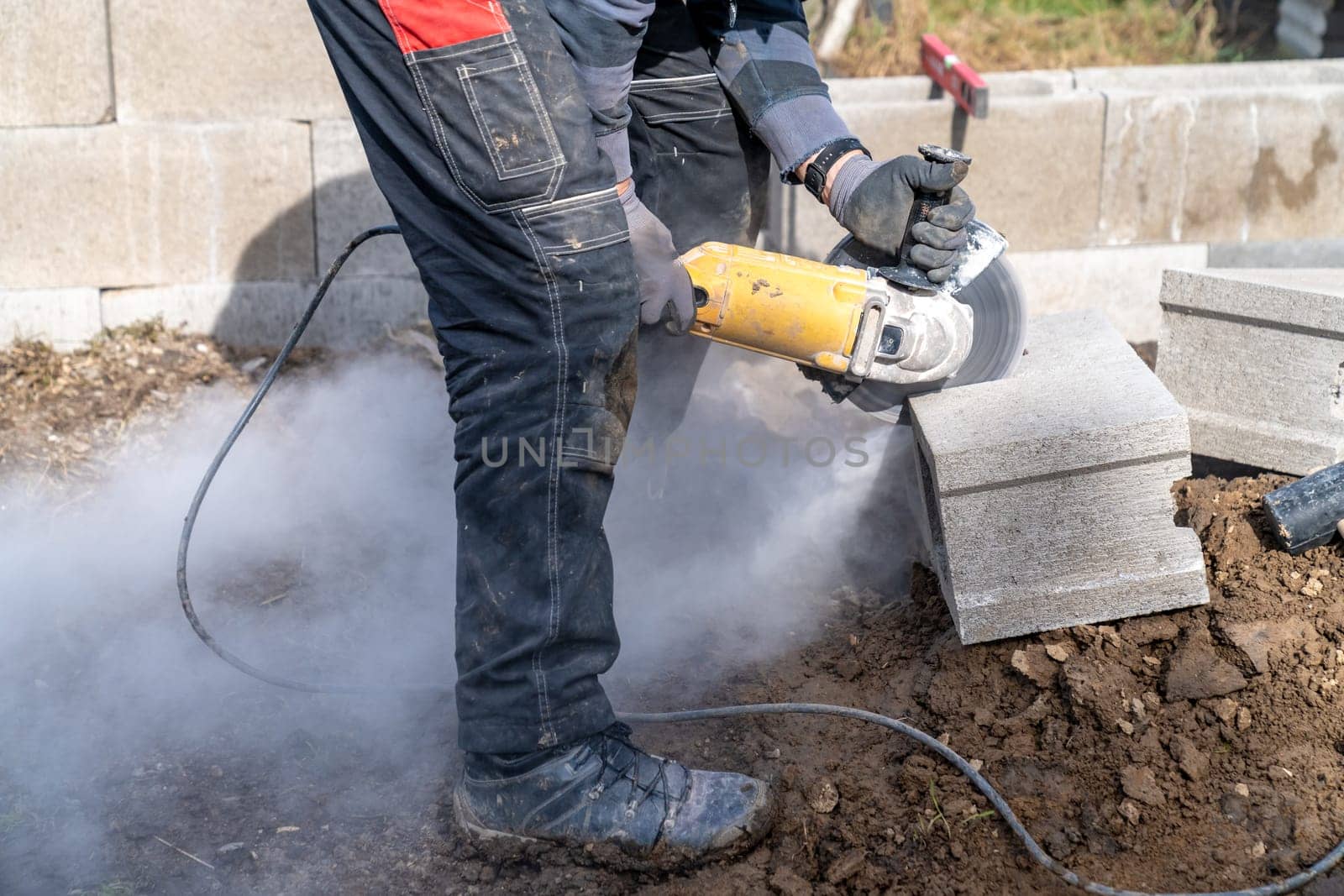 cutting concrete bricks with an electric grinder.