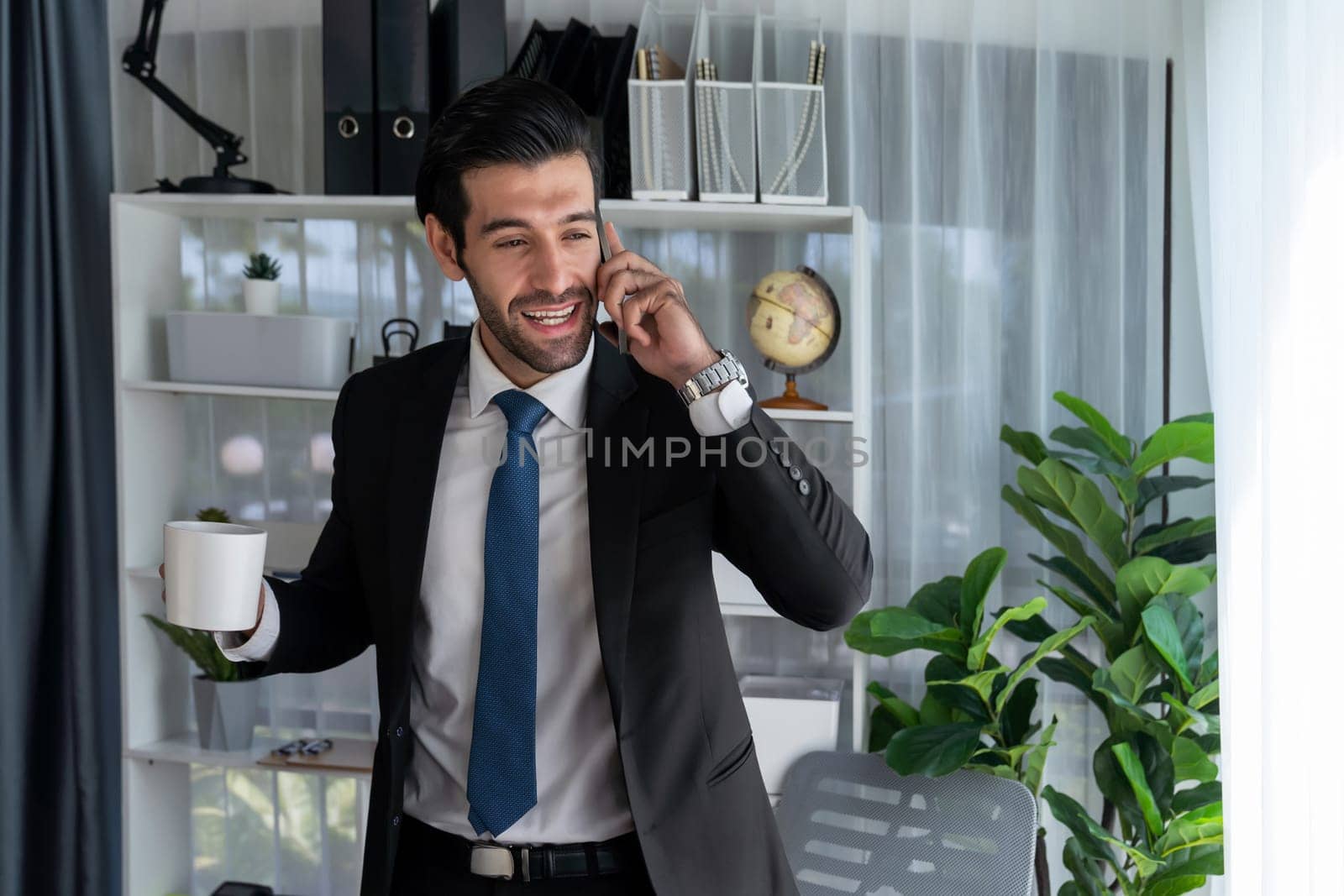 Diligent businessman talking on phone call with coworker in office. Fervent by biancoblue