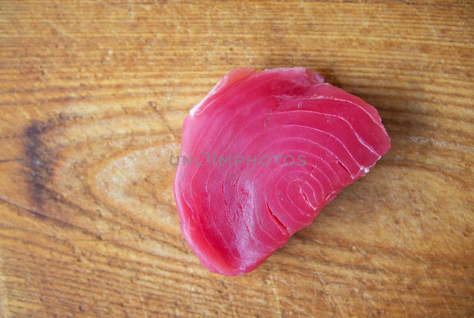 Raw tuna steak on a wooden board, top view. Delicious and healthy food for the body. by sfinks